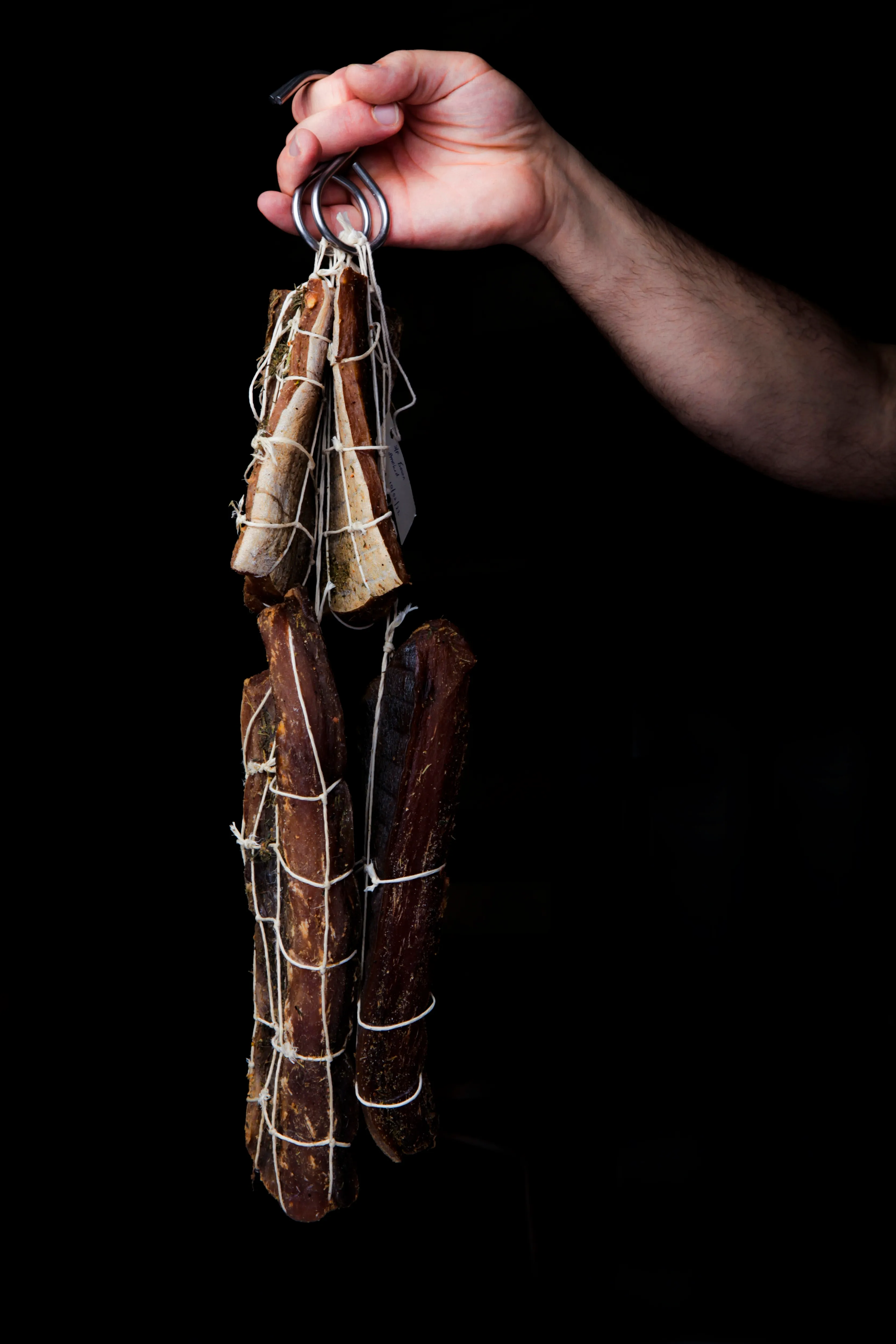 House-cured fish hanging on a hook